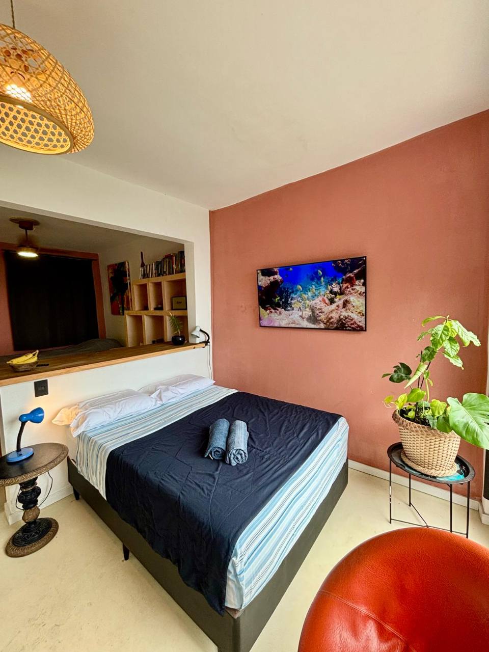 Cama de casal e TV no estúdio Maracujá.