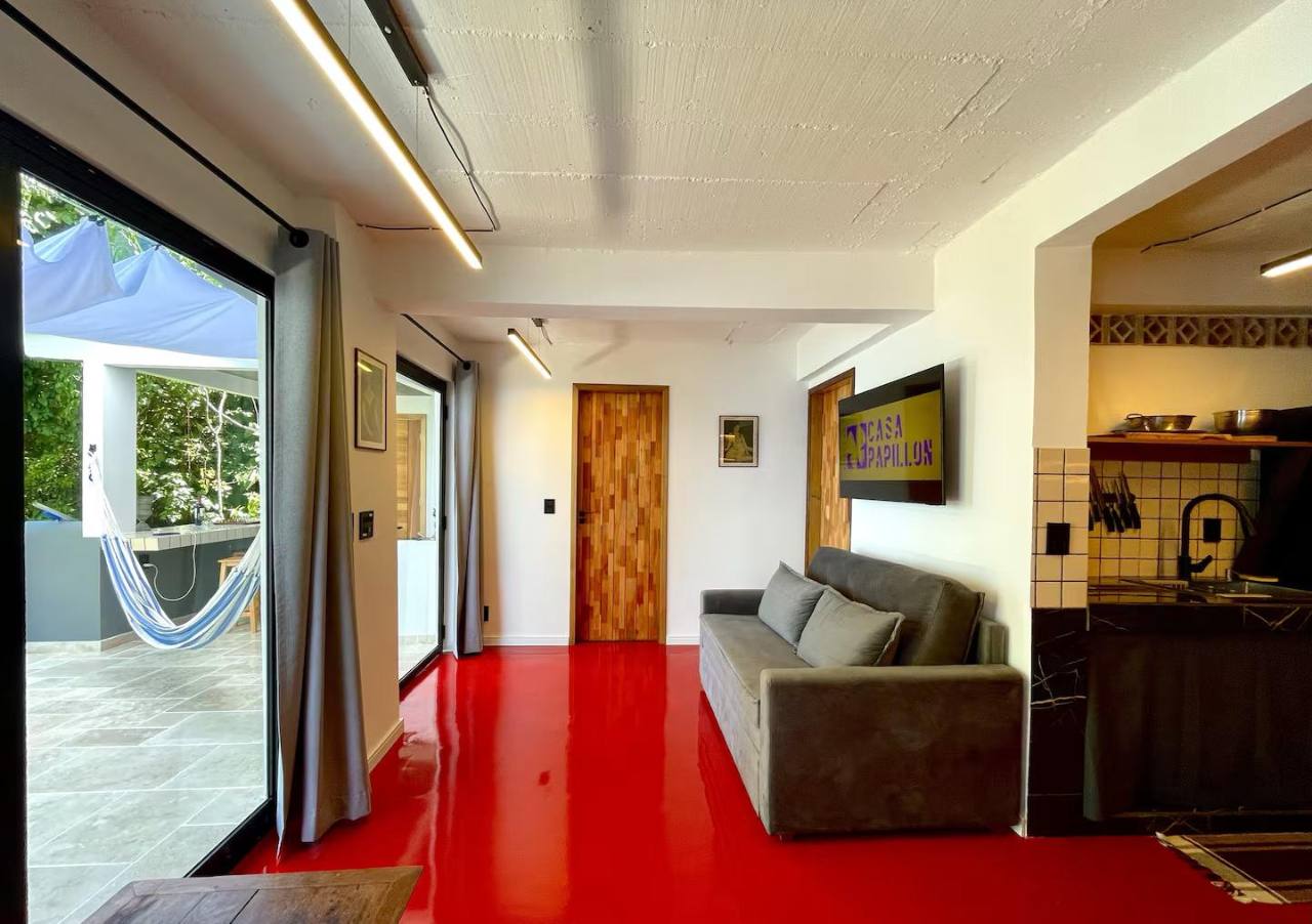 Abrir foto em tela cheia Sala de estar luminosa com cozinha equipada e acesso direto ao terraço.