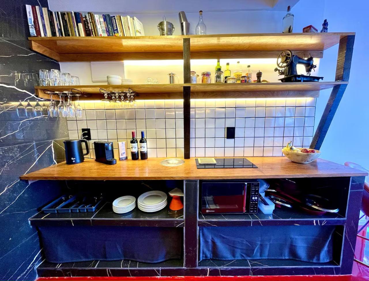 Abrir foto em tela cheia Bancada equipada da cozinha com louças, cafeteira e espaço para cozinhar.