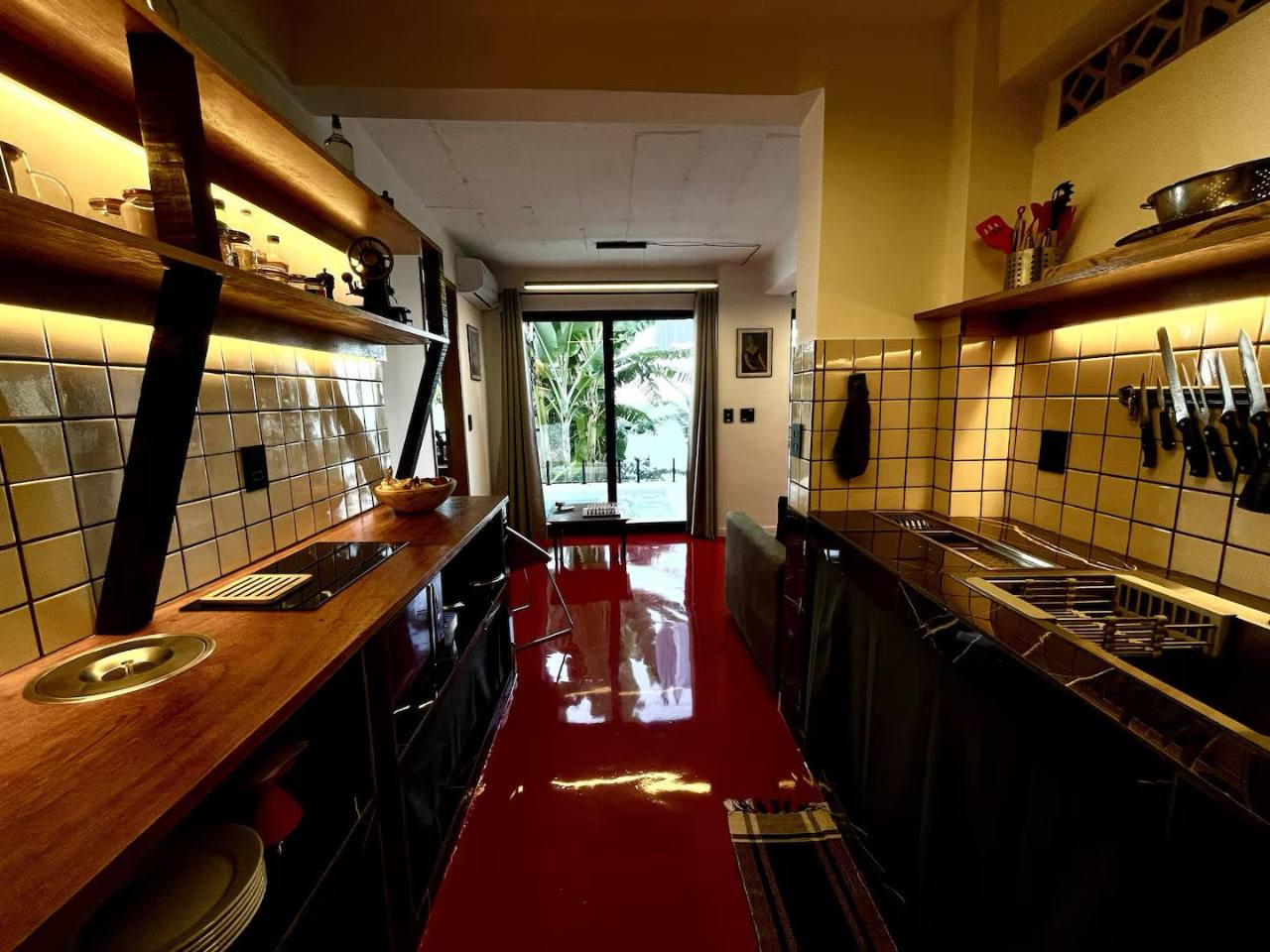 Abrir foto em tela cheia Cozinha equipada com perspectiva aberta para a sala e o terraço tropical.